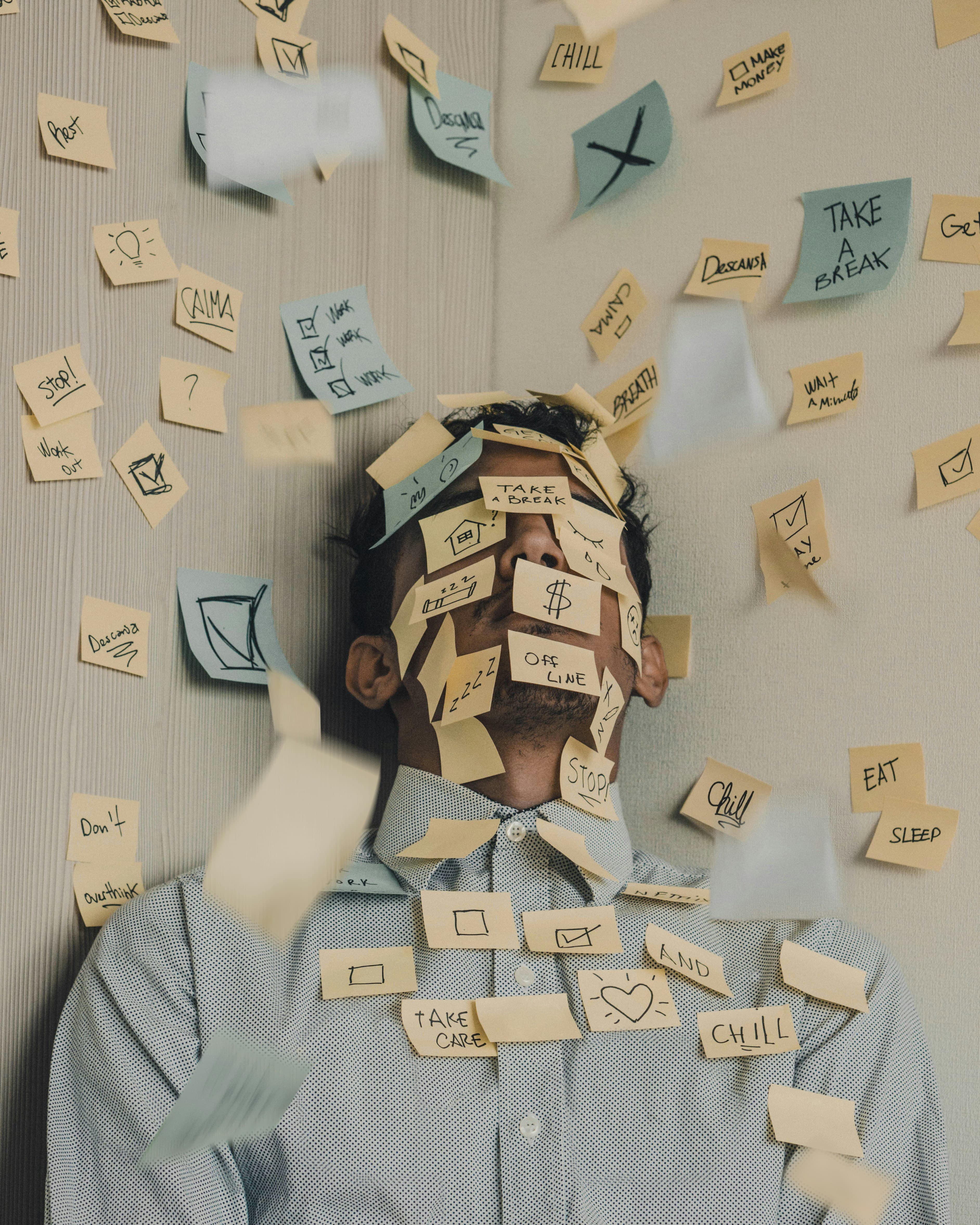 Persona saturada de post-its representando una agenda caótica